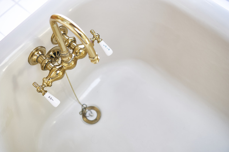 Vintage brass faucet in bathtub