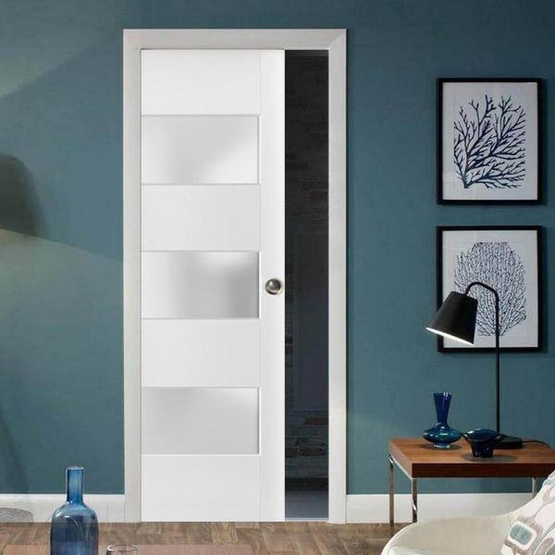 A white closet pocket door in a blue bedroom