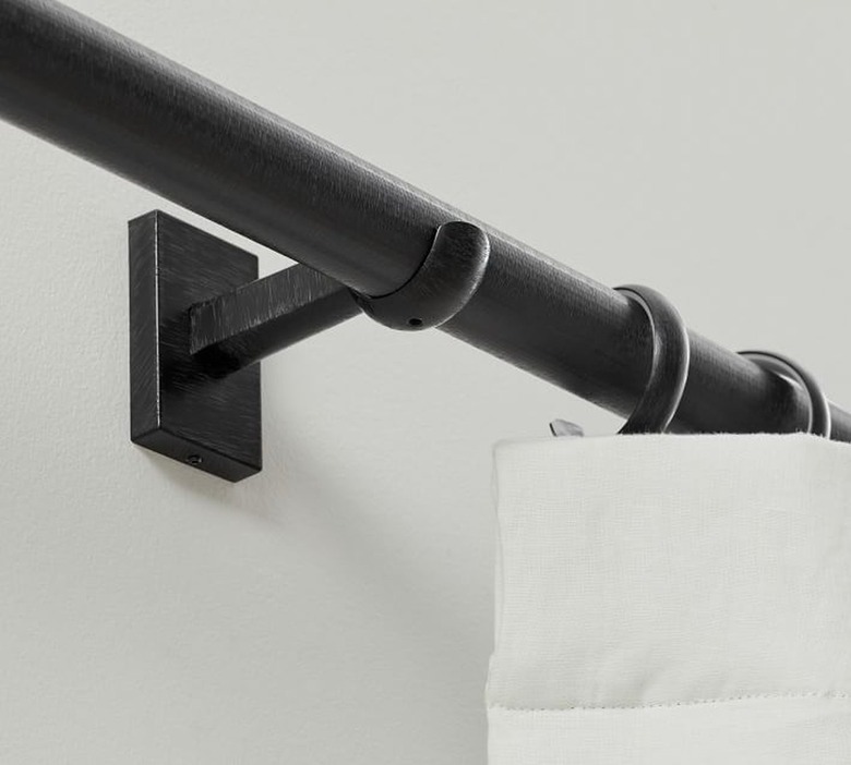 A black curtain rod on a black bracket