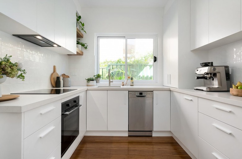 small white u-shaped kitchen with window