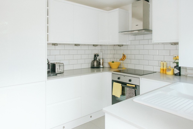 white minimalist u-shaped kitchen with yellow touches