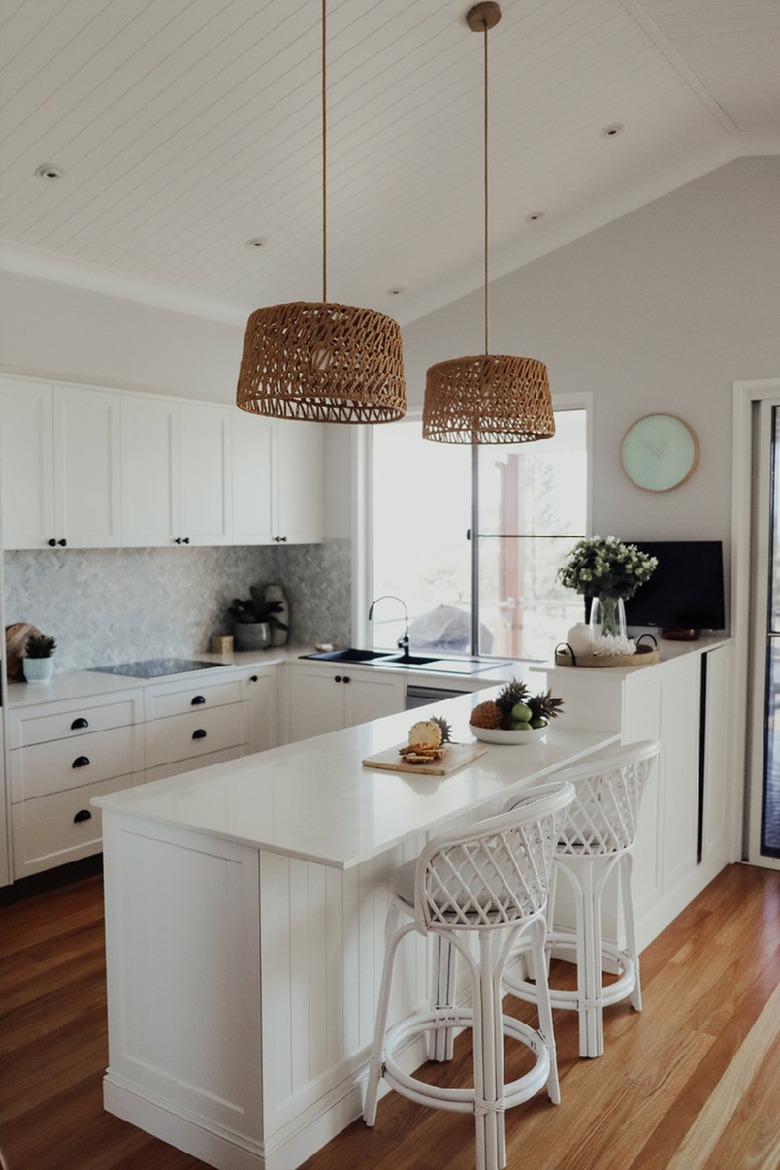 white u-shaped kitchen with rattan pendant lights