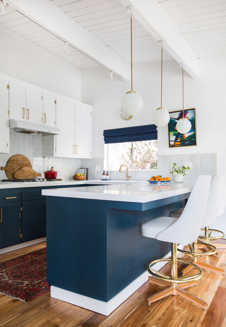 blue and white u-shaped kitchen with globe style pendants