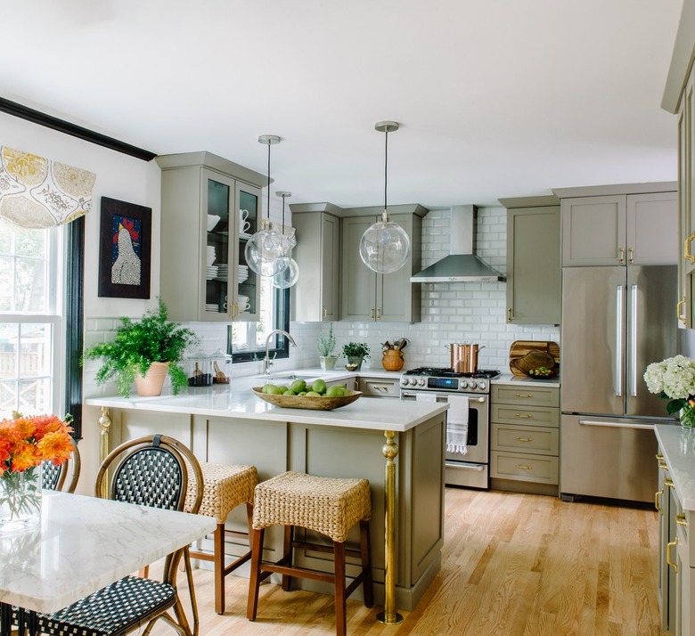 green u-shaped kitchen with clear glass pendants