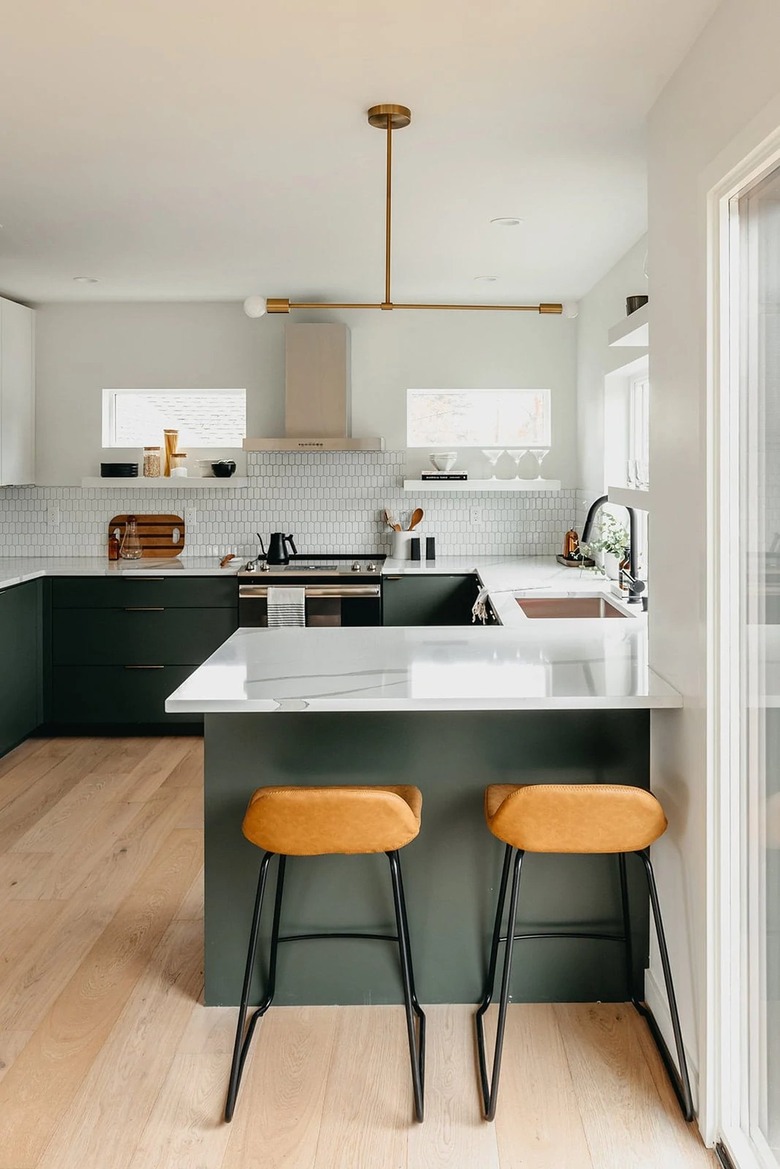 green u-shaped kitchen with modern chandelier