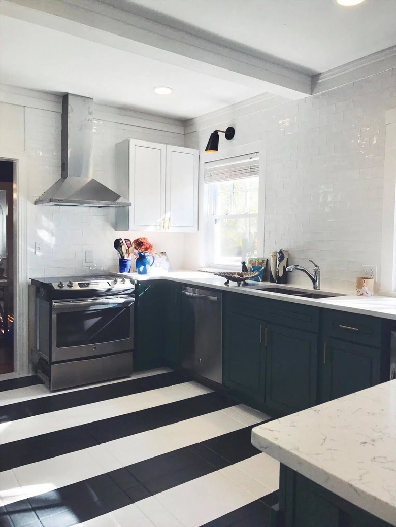 black u-shaped kitchen with black and white striped floor