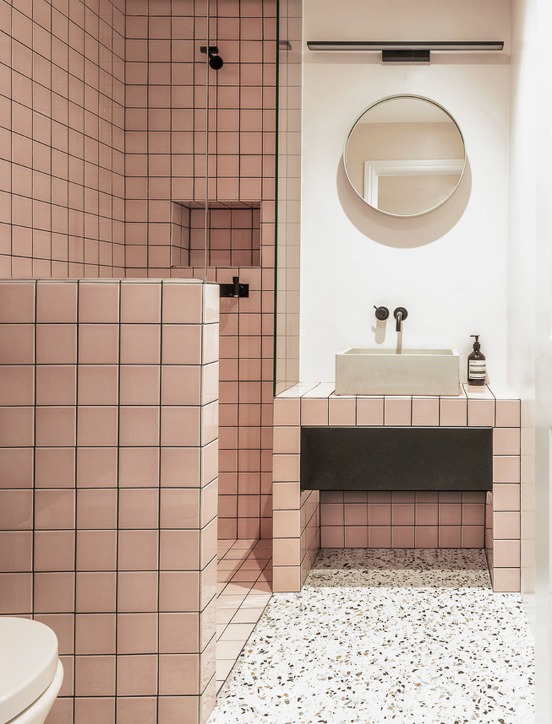 concrete trough bathroom sink in pink tiled bathroom with terrazzo flooring