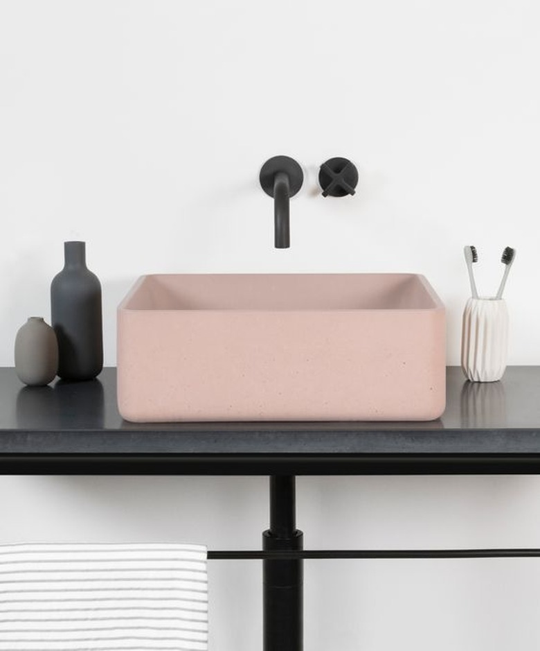 blush pink concrete bathroom sink with black fixtures