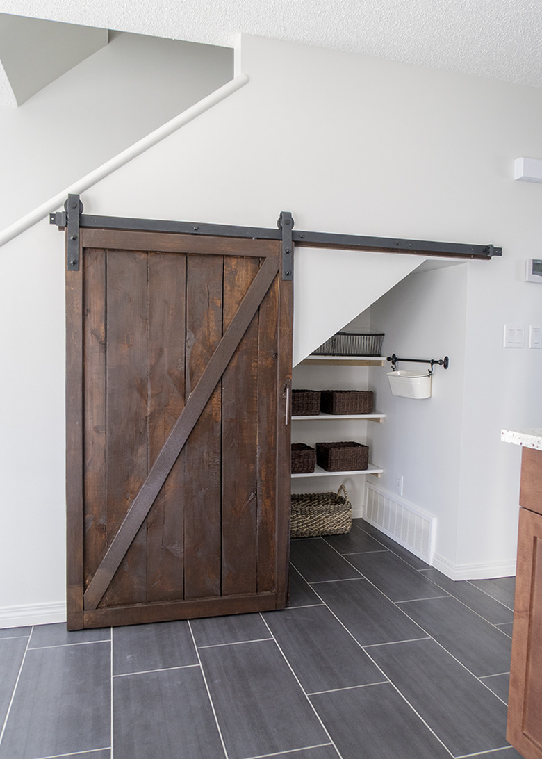 Under the stairs storage with DIY wood barn door and shelving