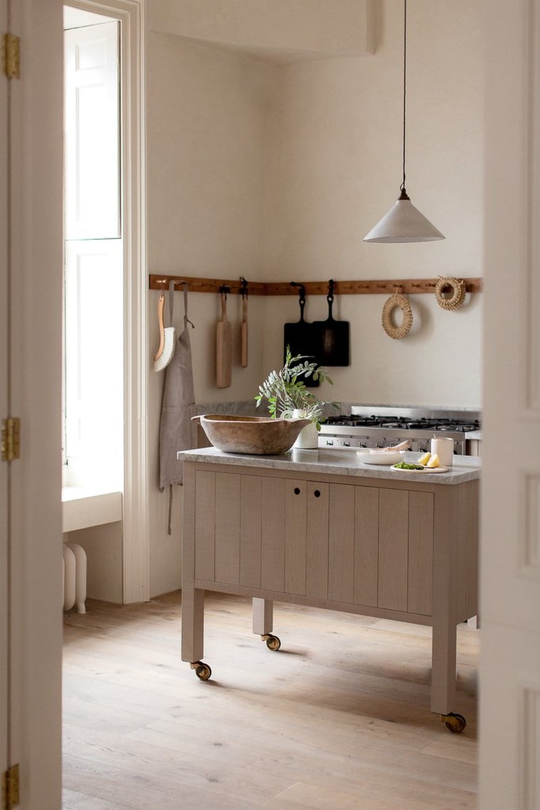 warm minimal kitchen storage idea with wooden rail