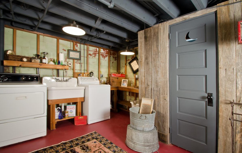 gray unfinished basement idea with red floors and laundry