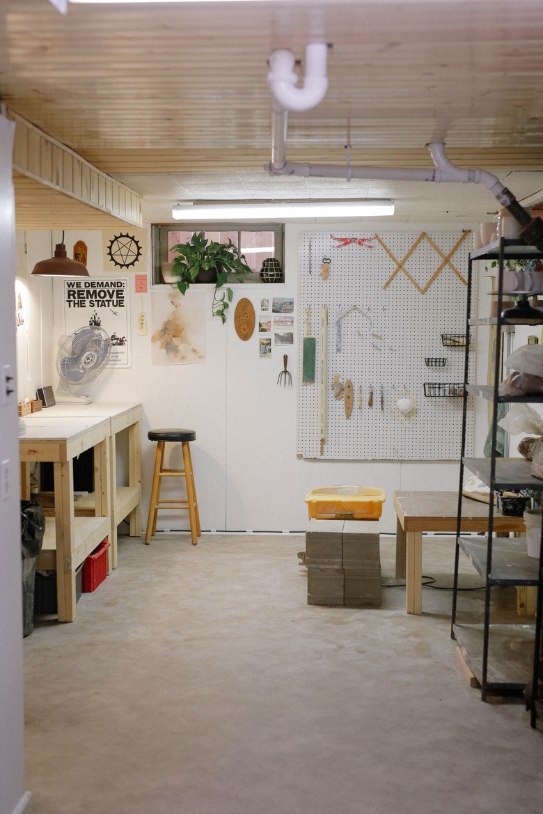 white unfinished basement idea with workspace and shelving