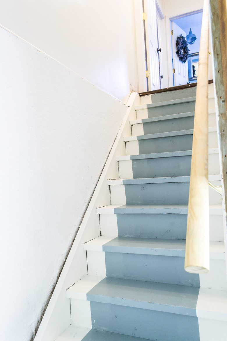 white unfinished basement idea with stairs with painted blue runner