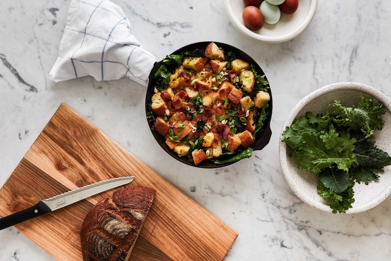 Wood cutting board, cast iron pan, dishes of food