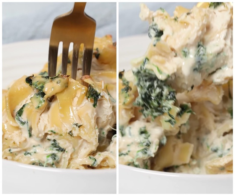 Fork with vegan spinach noodle kugel from a white plate.