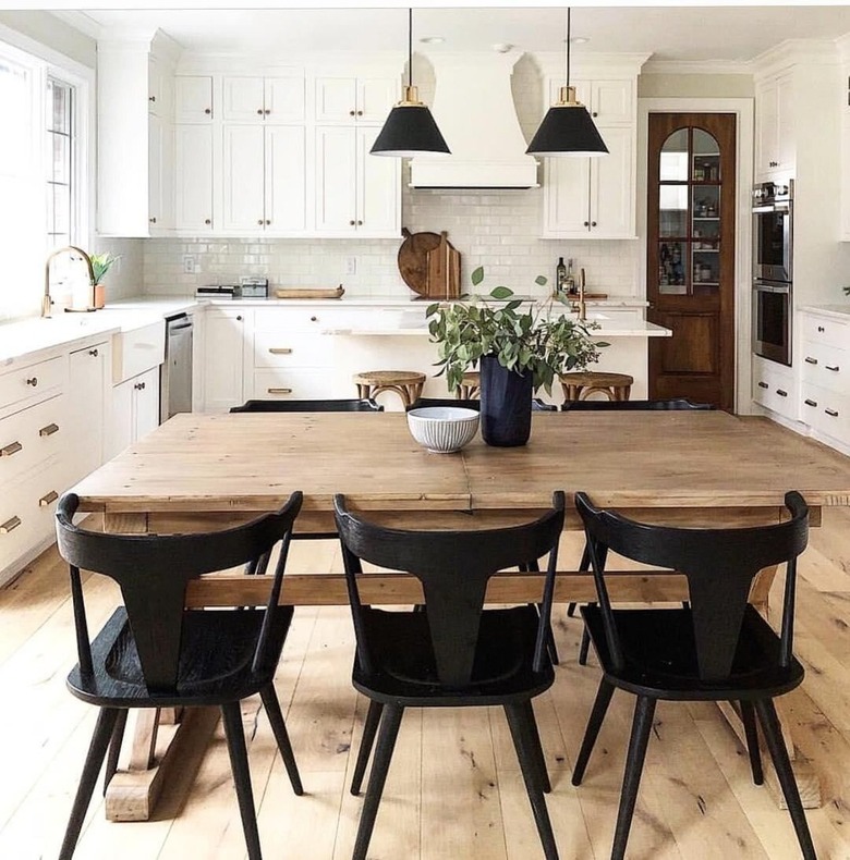 A light wood farmhouse dining table in a white kitchen.