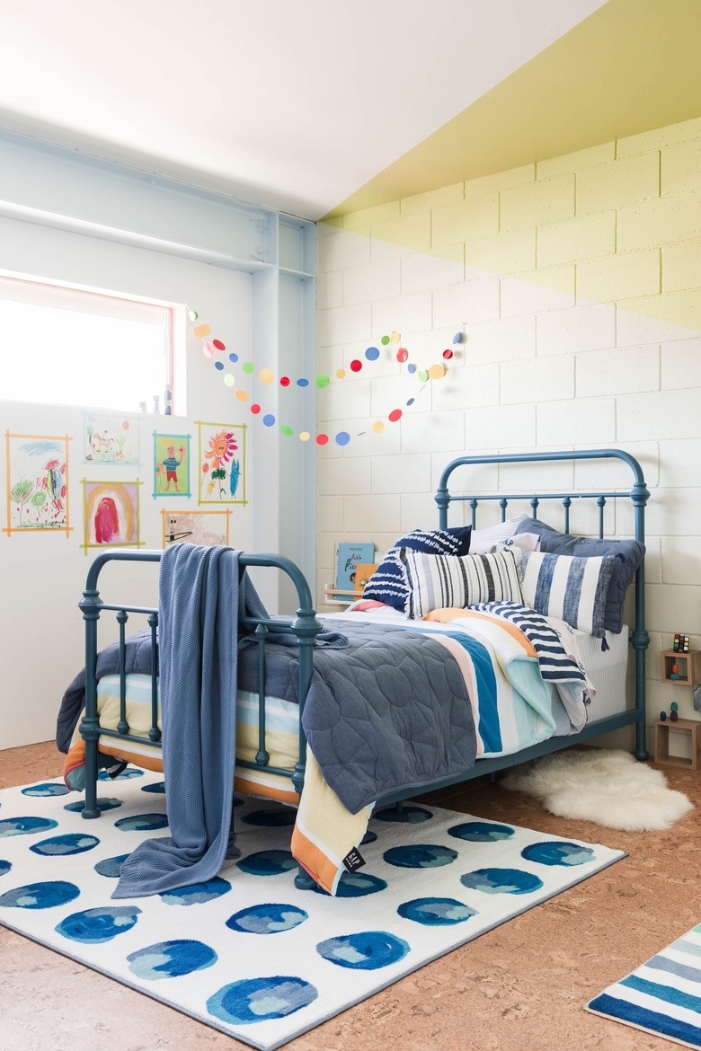 bedroom with light brown floors and light blue and yellow walls