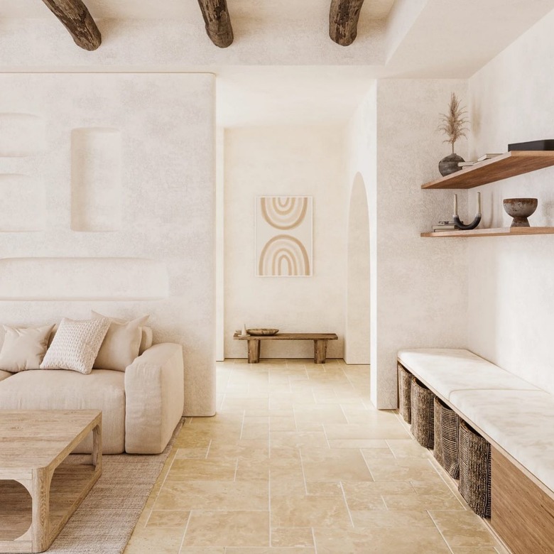 A rustic cream, beige, and brown living room with travertine floors and wood beam ceiling