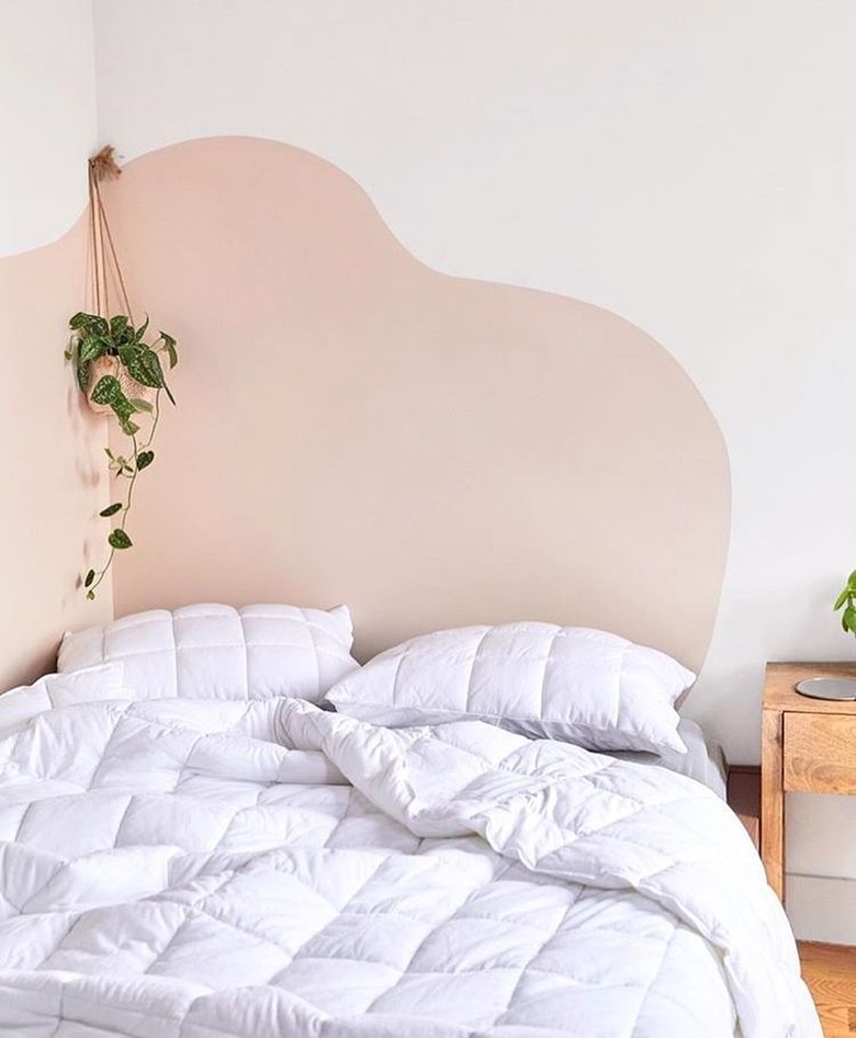 bedroom with white bedding and a wavy accent wall