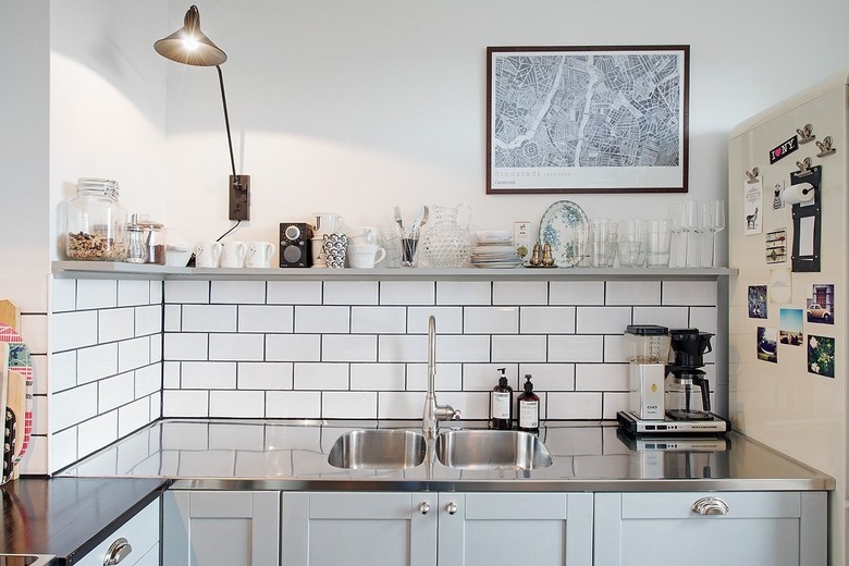 Scandinavian kitchen with stainless steel countertops and white subway tile backsplash