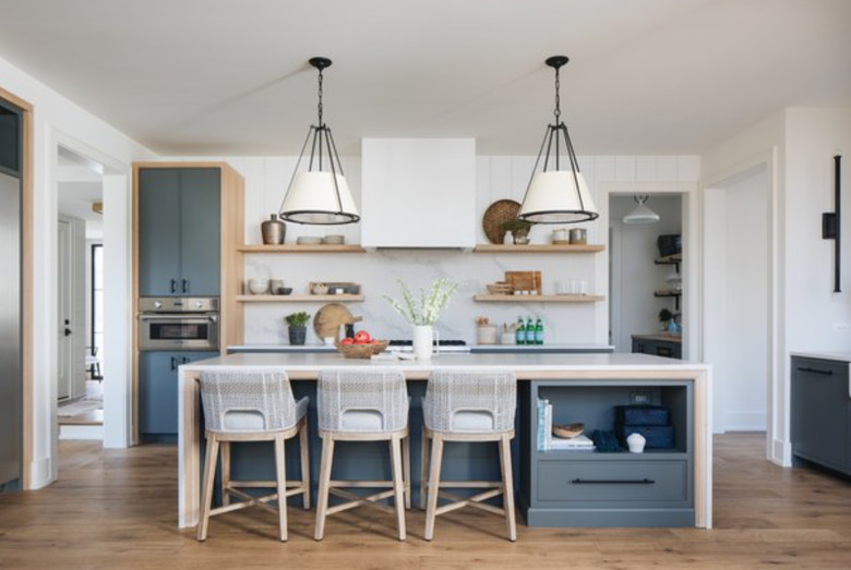 Waterfall kitchen island with gray base and two farmhouse pendant lights