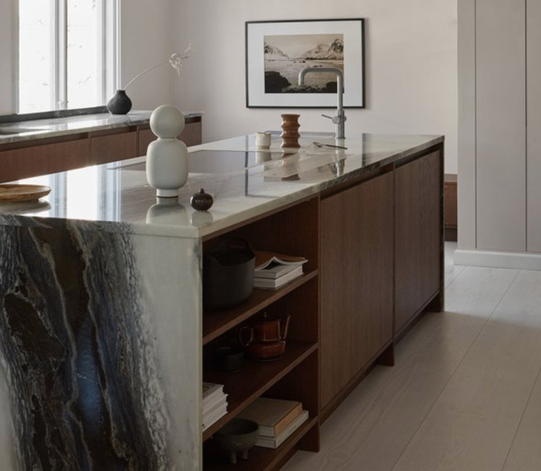 Waterfall kitchen island with gray marble, dark wood cabinets.