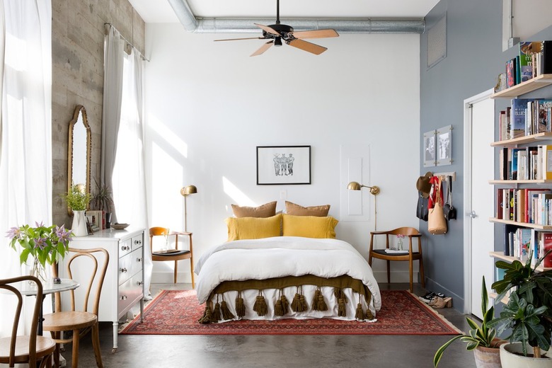 bedroom with white bedding and yellow pillows and brown tassled blanket