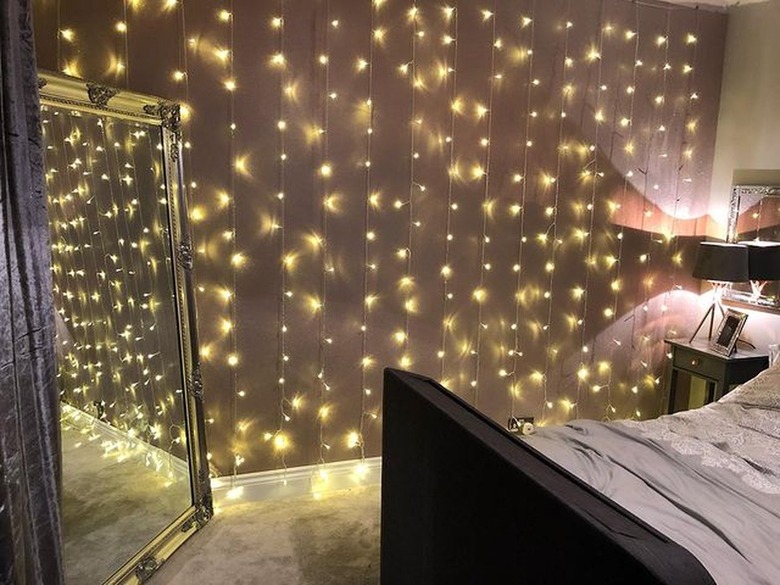 Drape fairy lights along a wall