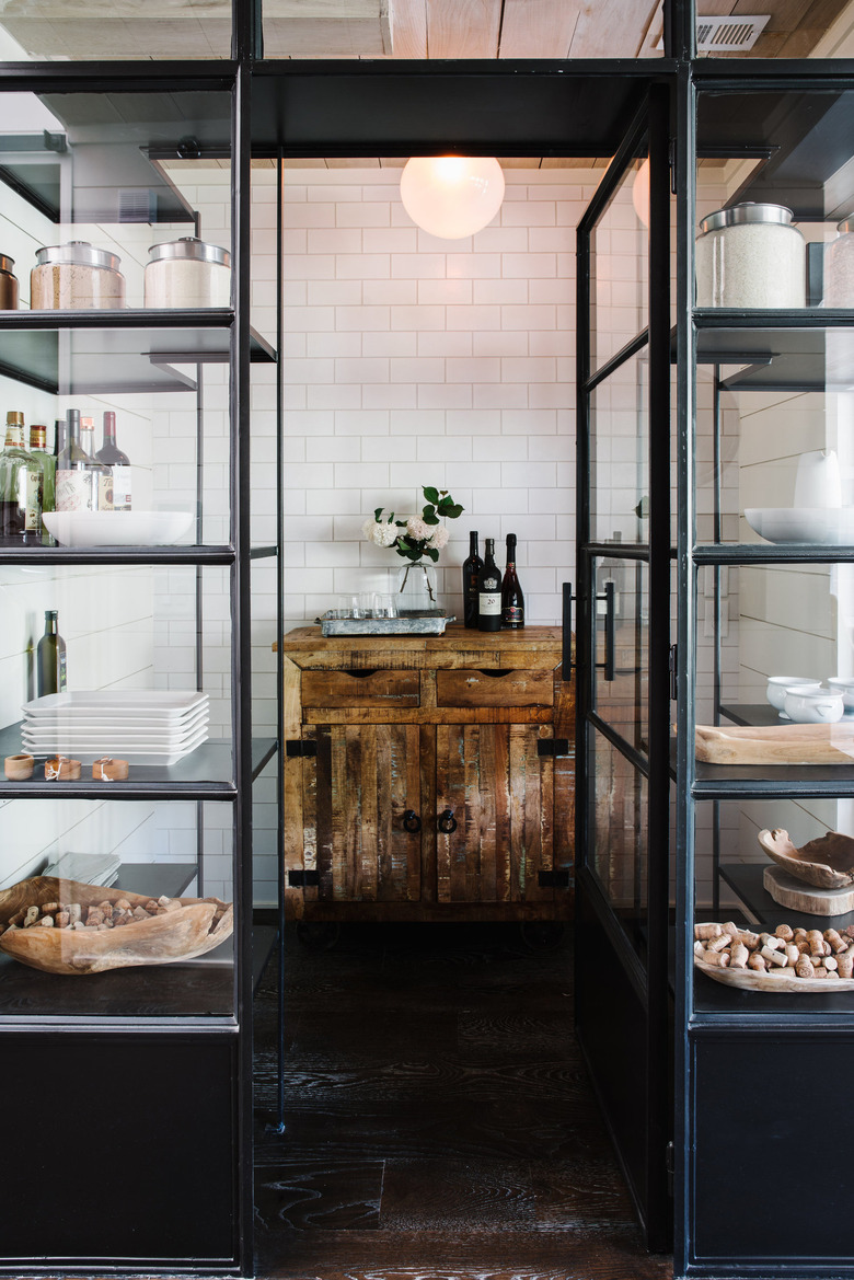 open kitchen pantry with distressed cabinet and white subway tile wall