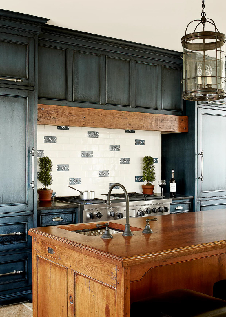 blue kitchen with distressed cabinets and wood island