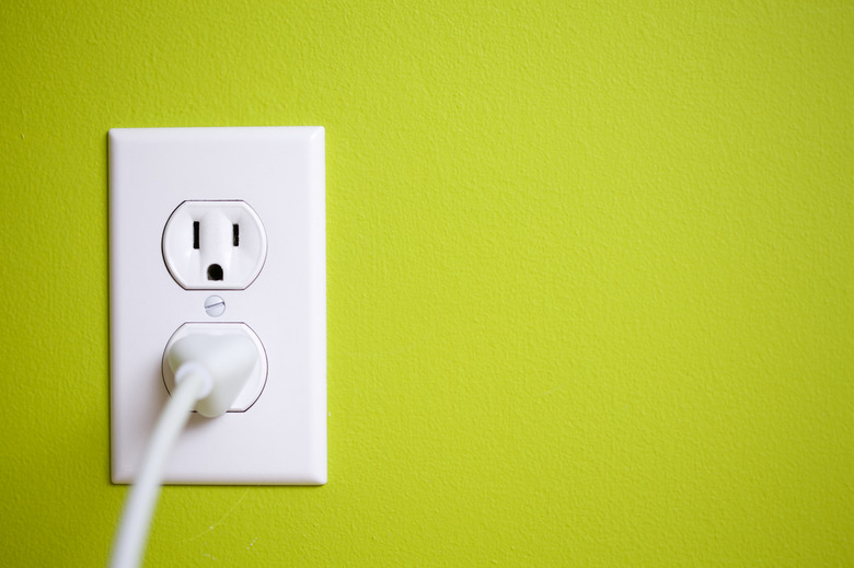 A green wall with a power socket