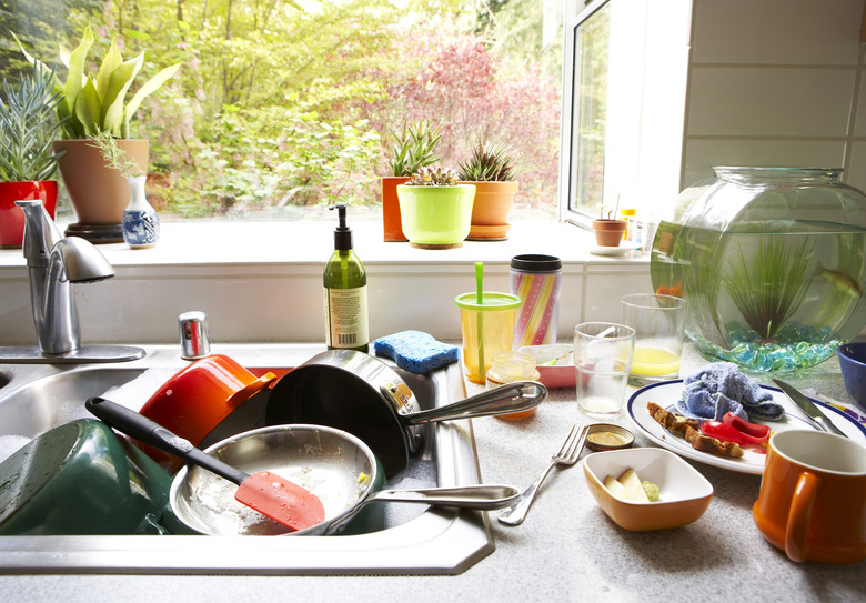 Dirty dishes piled in kitchen sink, close-up