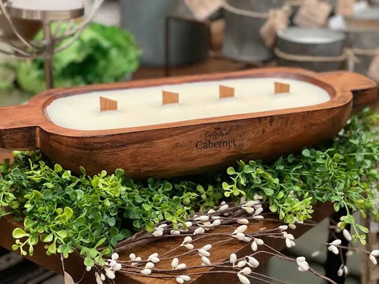 A citronella candle in a wood basin