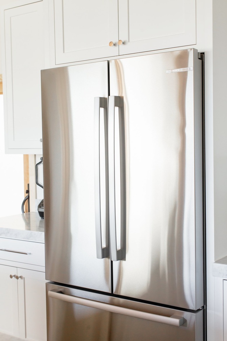 Stainless steel refrigerator with double doors and a pullout freezer.