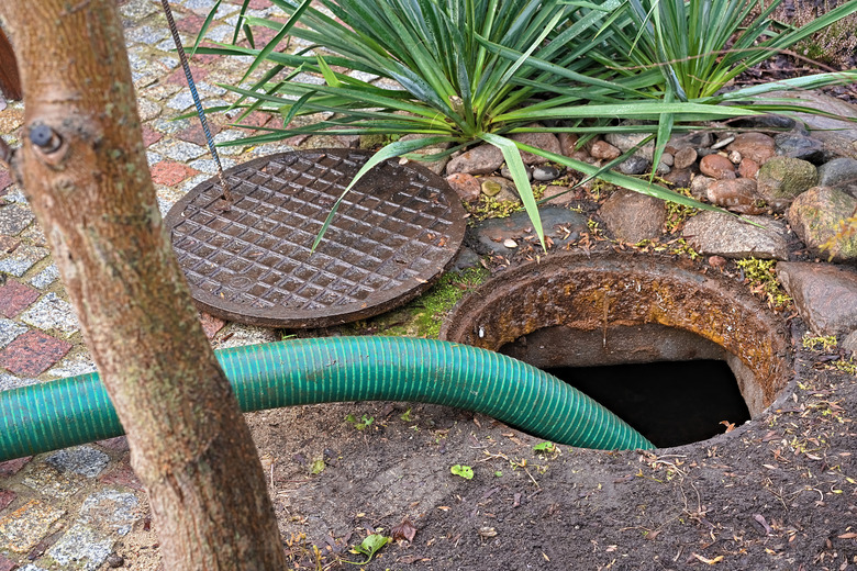 Pumping a septic tank in a rural backyard.