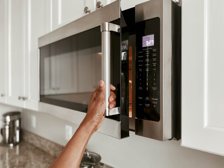 Closeup of Woman Opening Microwave