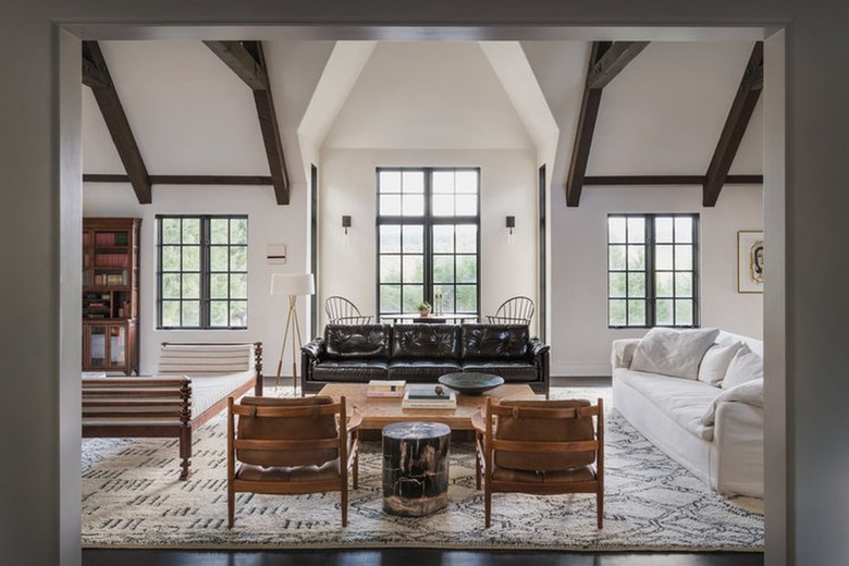 cream living room with black sofa, brown chairs