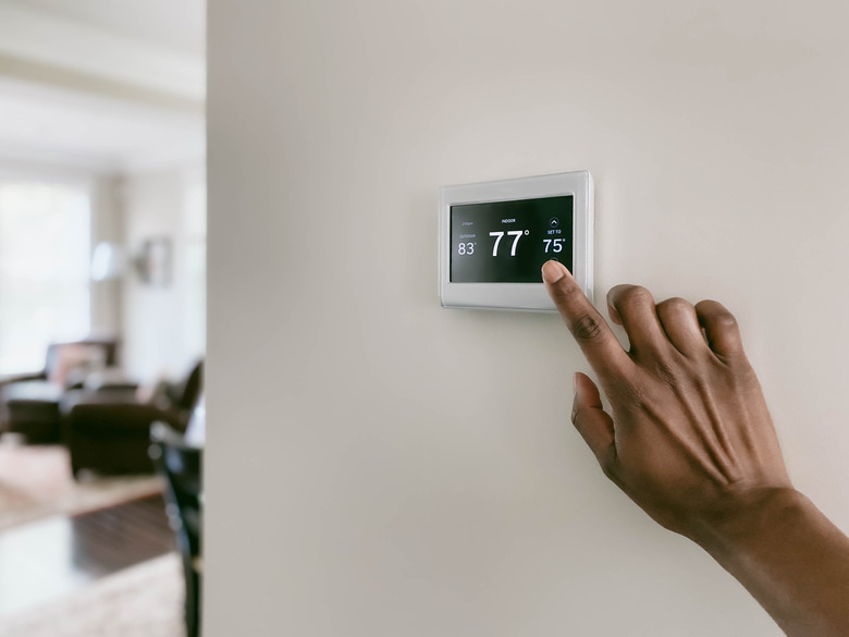 Woman Adjusts Thermostat