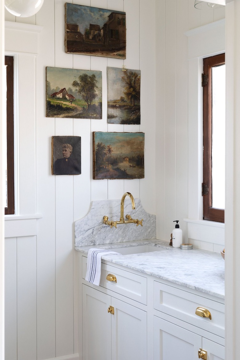 white farmhouse butler's pantry with sink and vintage oil paintings