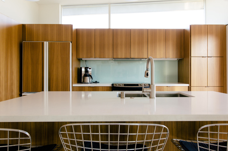 kitchen with wood paneled cabinets, white countertops and kitchen island with a sink