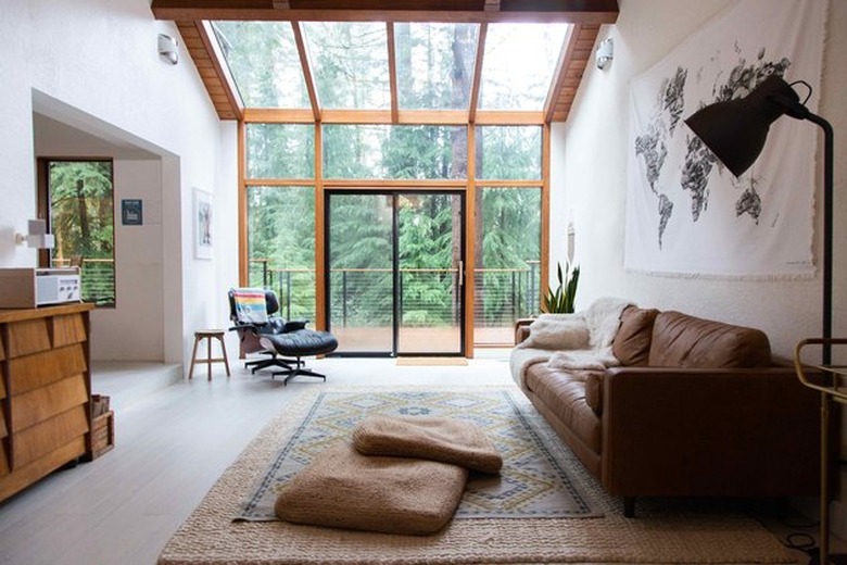 Living room space with large windows, couch and chair