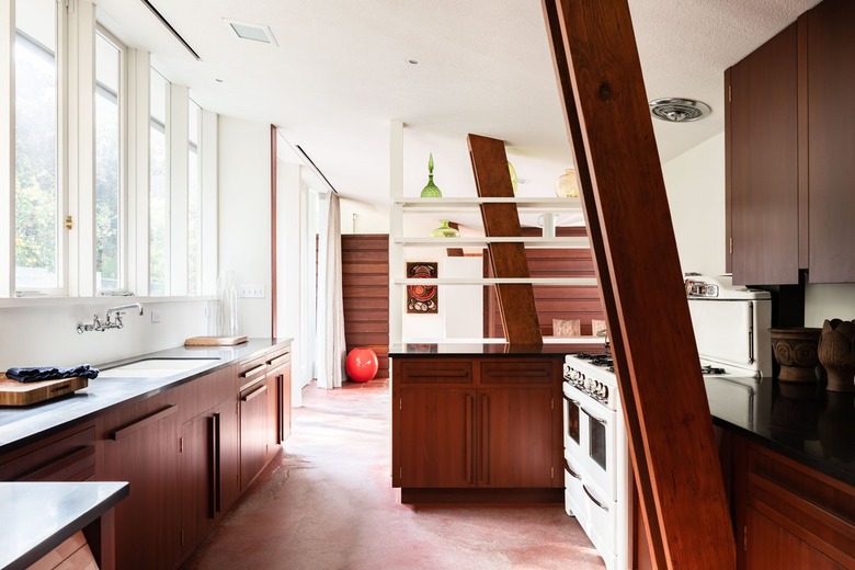 Mid-century kitchen with white walls, building-in shelving, wood cabinets and beams