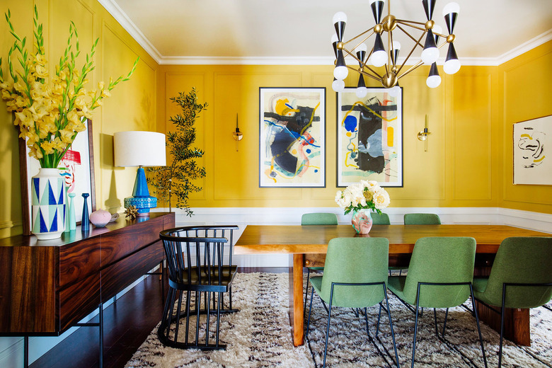 yellow dining room with green chairs