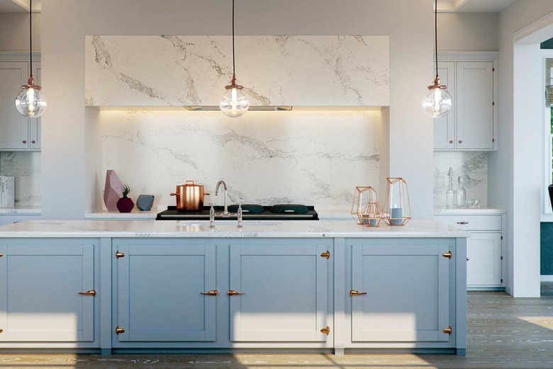 blue kitchen with engineered stone countertop and backsplash