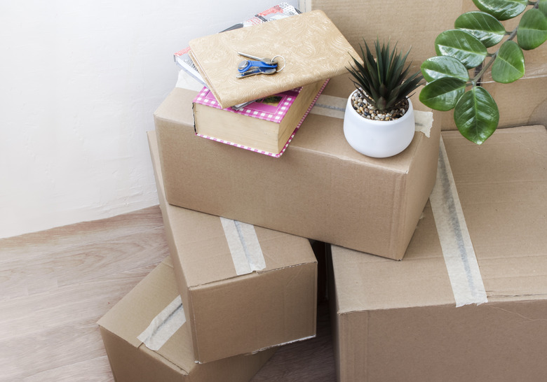 full boxes of things with indoor flowers and keys to a new house, moving to another housing, top view