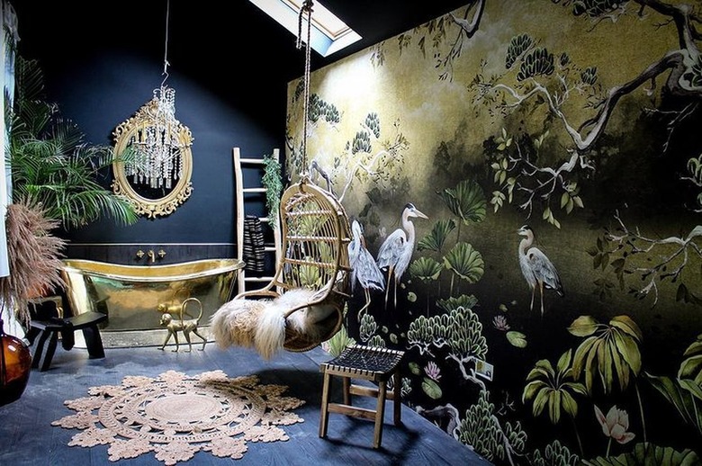 Room with tub, colorful wallpaper with cranes, and swinging chair