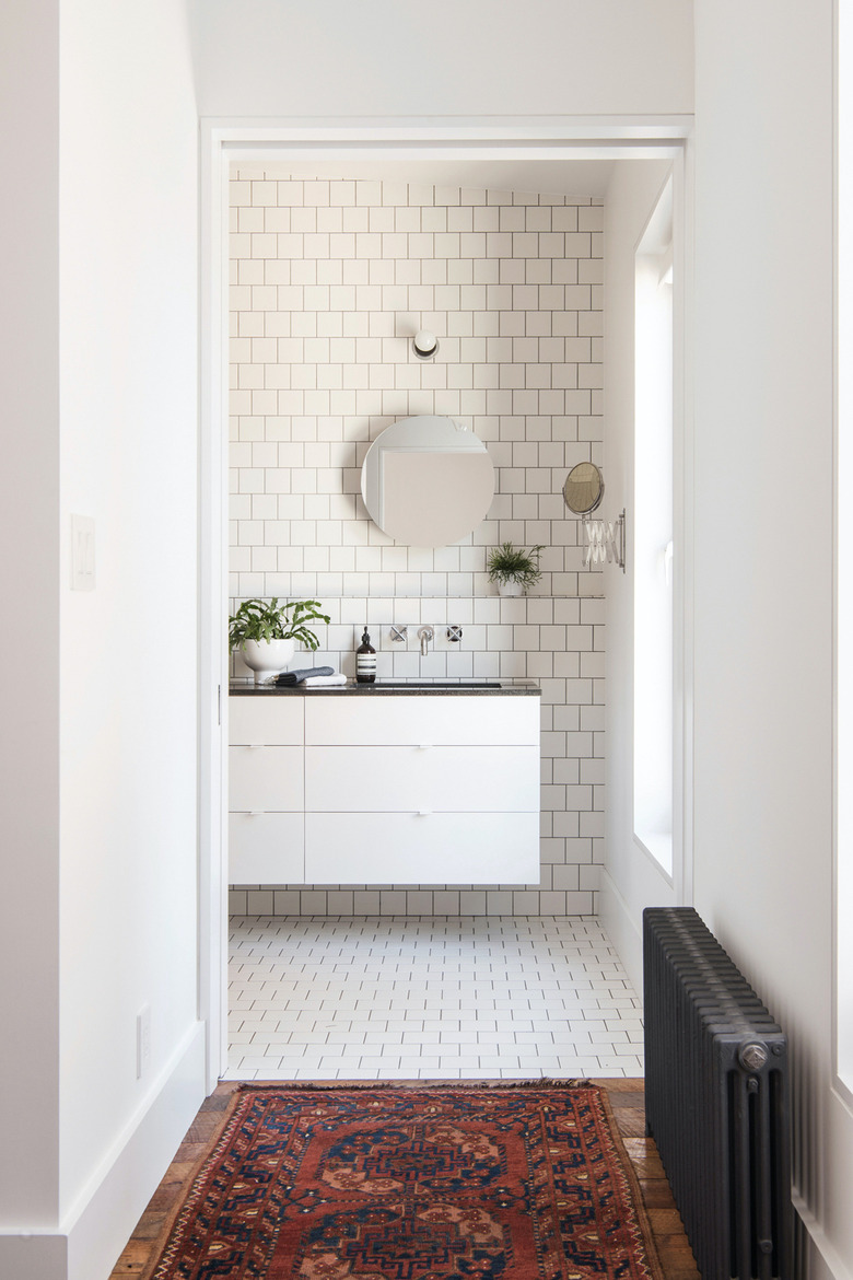 Floating White Bathroom Cabinet with subway tile wall and floor  by Elizabeth Roberts Architecture