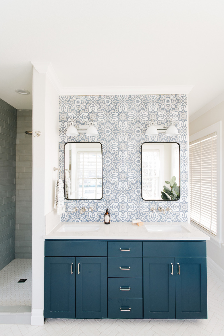 white bathroom countertop with blue cabinets and blue and white patterned backsplash