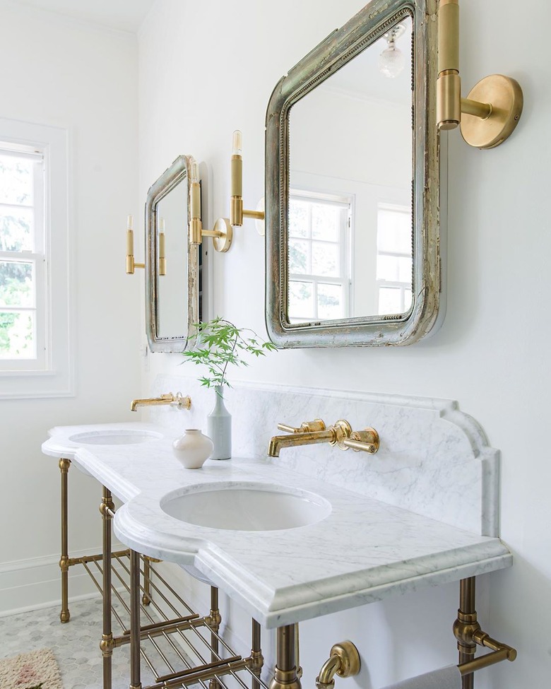 white bathroom countertop with traditional beveled in marble with console sinks and brass fixtures