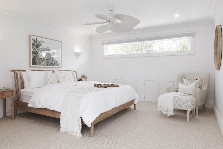 all white bohemian bedroom with wood bed and mirror